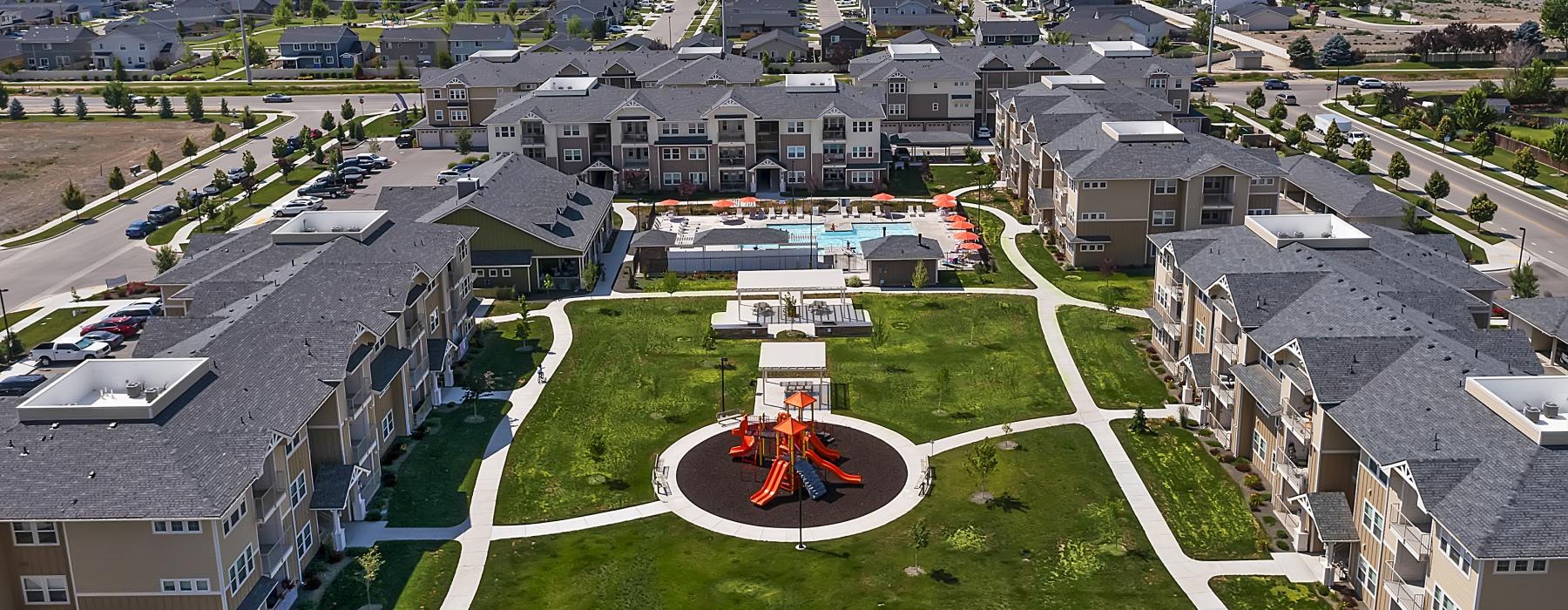 a large courtyard with buildings pool and a playground in the middle
