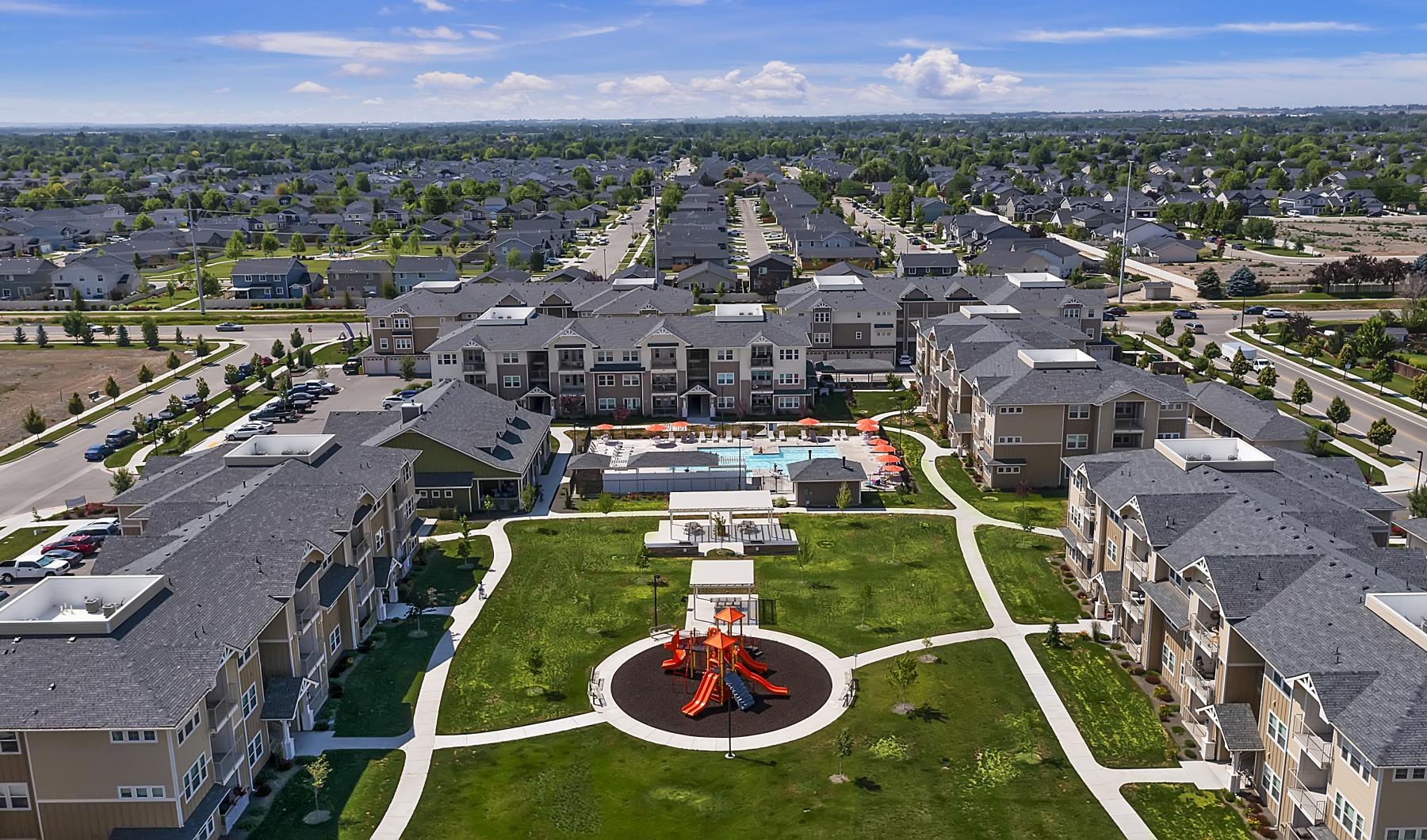 an aerial of many buildings and a child's playground and a pool