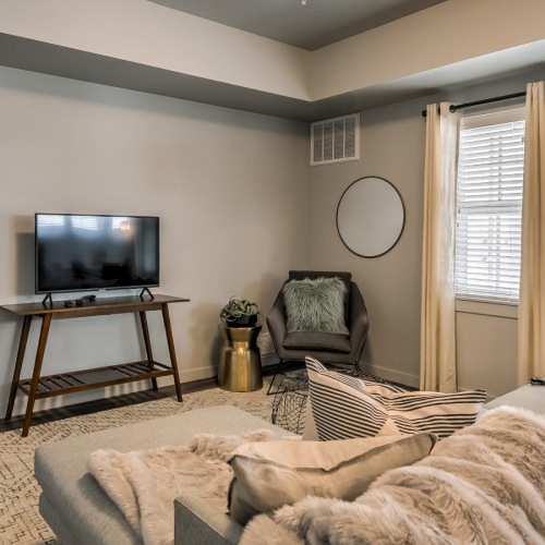 Open space living area with natural lighting and a large sofa and a tv